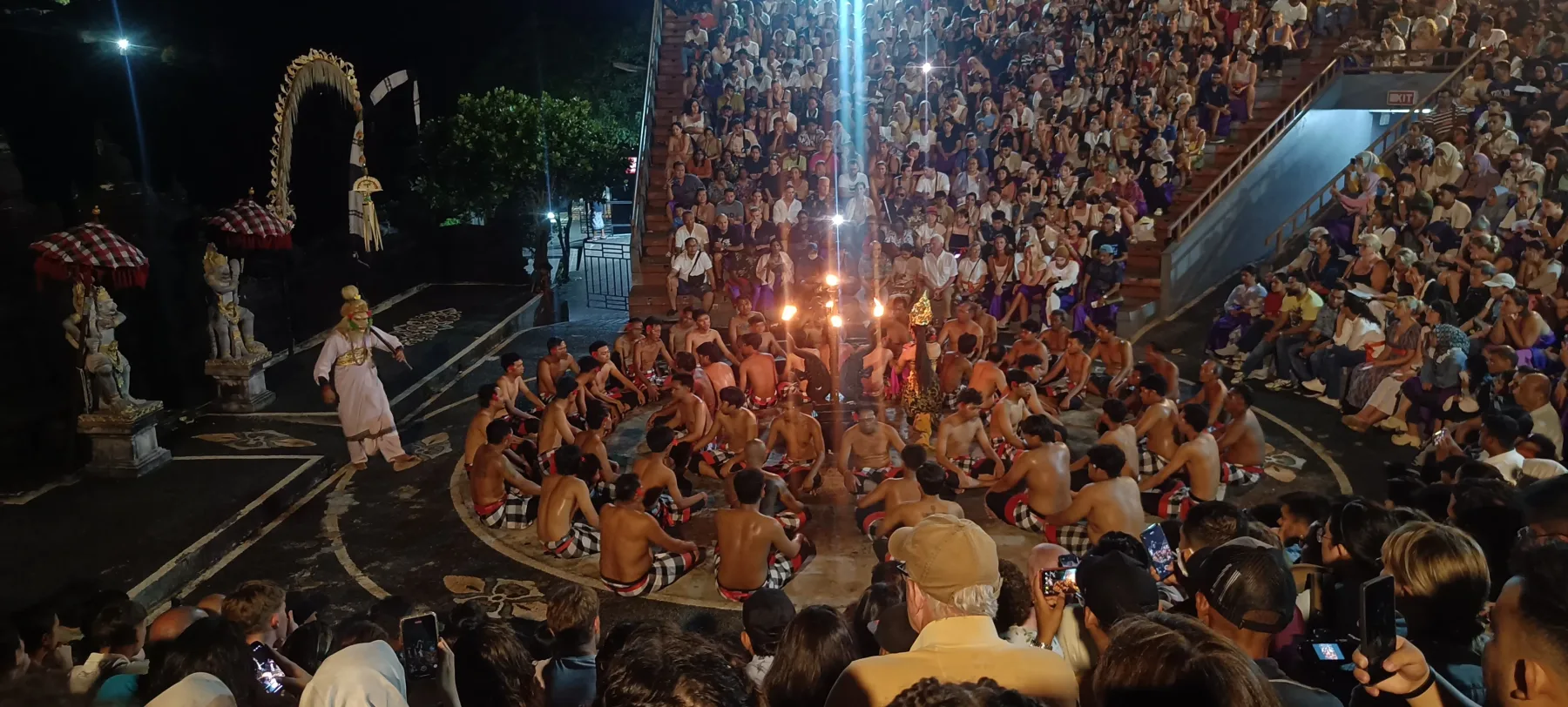 A nighttime Balinese cultural performance watched by a large audience